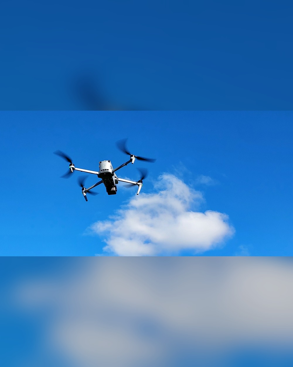 Autel enterprise drone in flight against a blue sky, photographed from below
