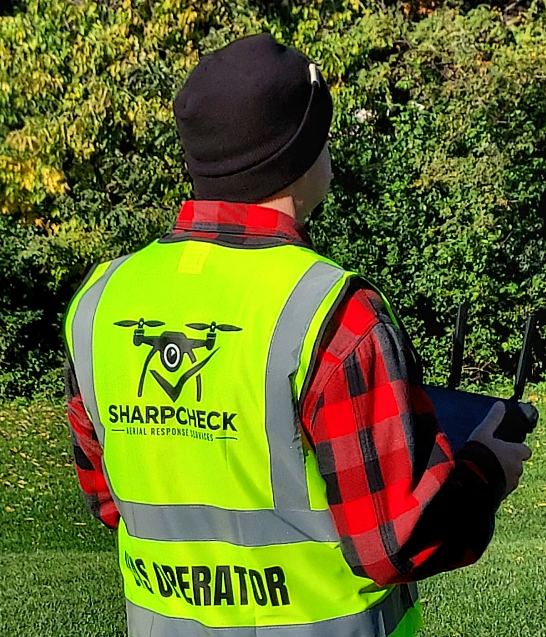 SharpCheck UAS operator wearing branded high-visibility safety vest